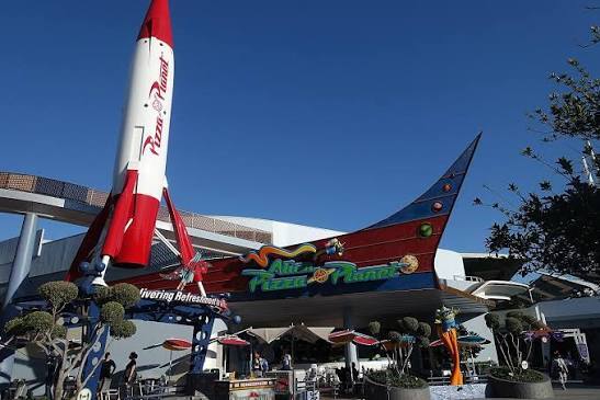 Alien Pizza Planet facade in Tomorrowland with the red-and-white rocket in view.
