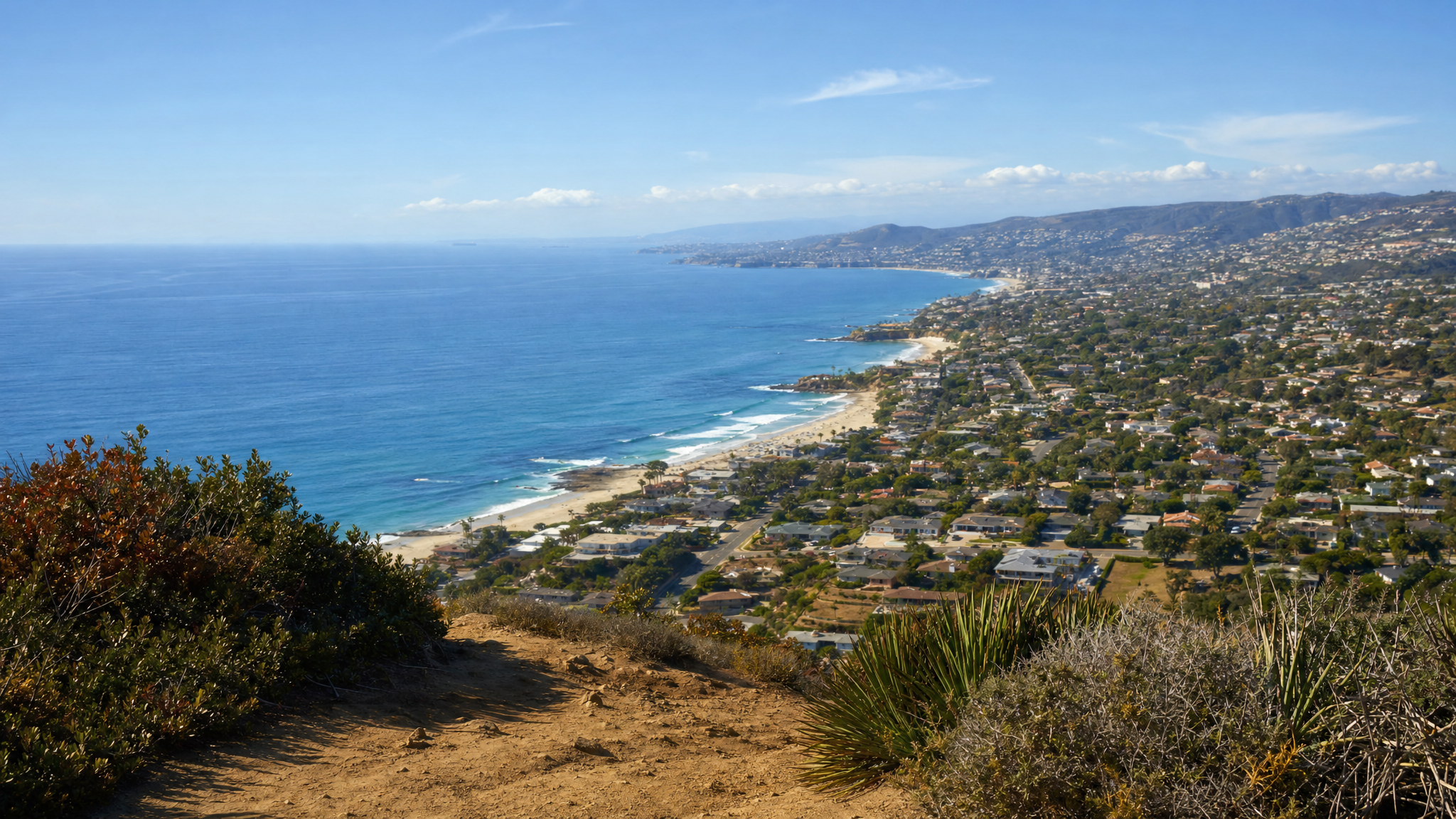 Wide overlook from Top of the World above Laguna Beach showing coastline, neighborhoods, and distant ocean in one high frame.